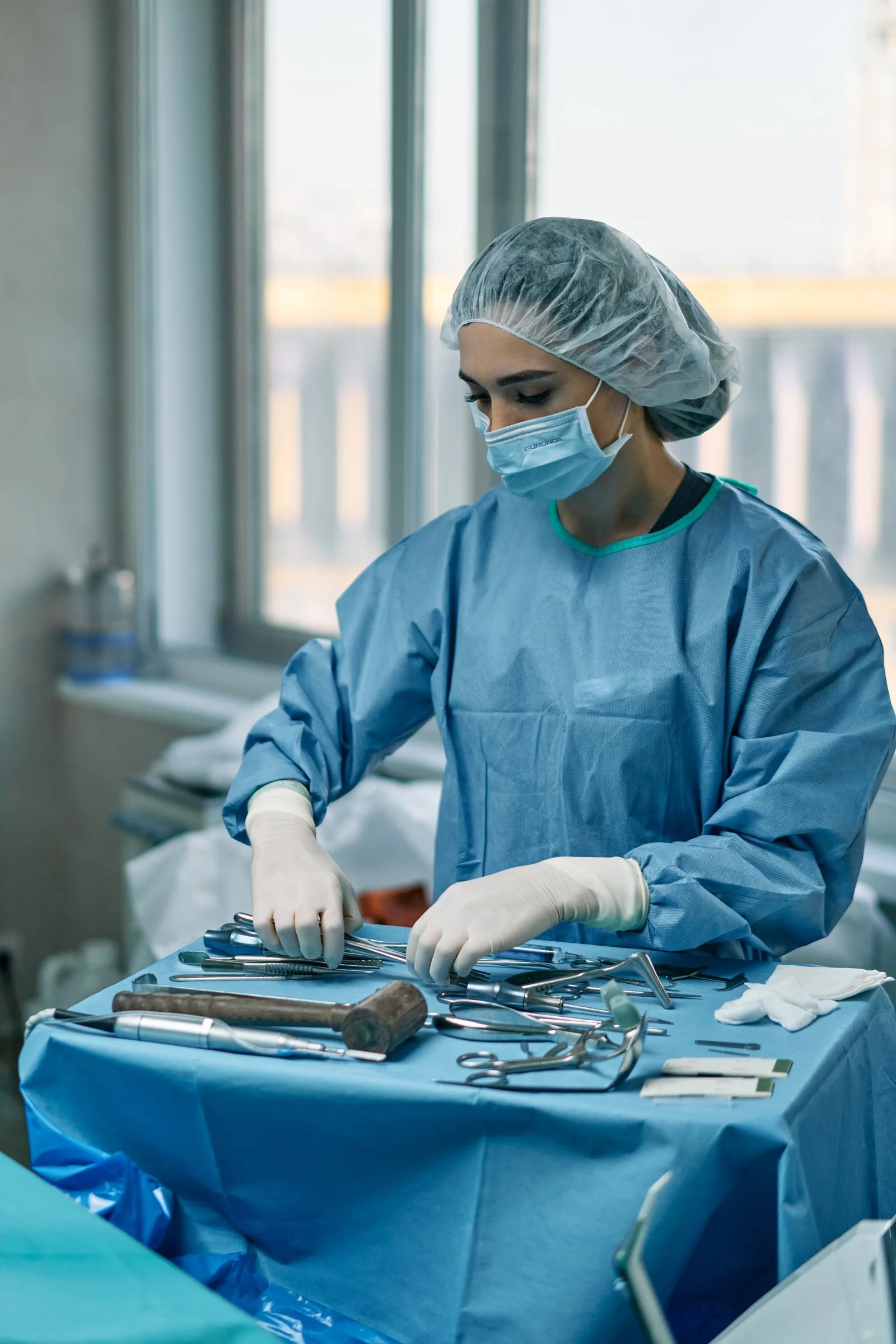 A clinical professional preparing instruments in an operating room